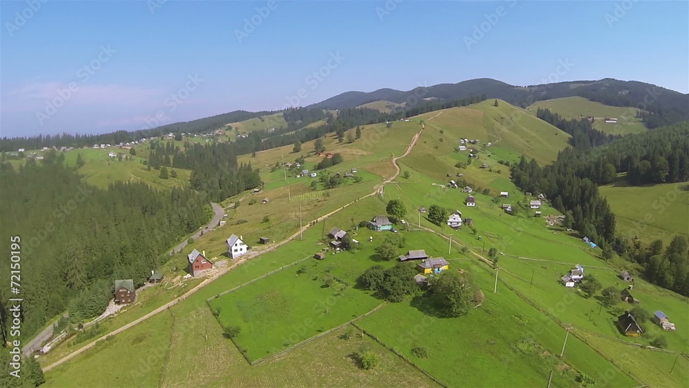 Flight over hill in mountains with village and wood. Aerial Flight over hill in mountains with village and wood. Aerial