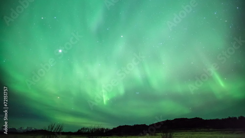 Northern lights aurora borealis in the night sky over beautiful photo