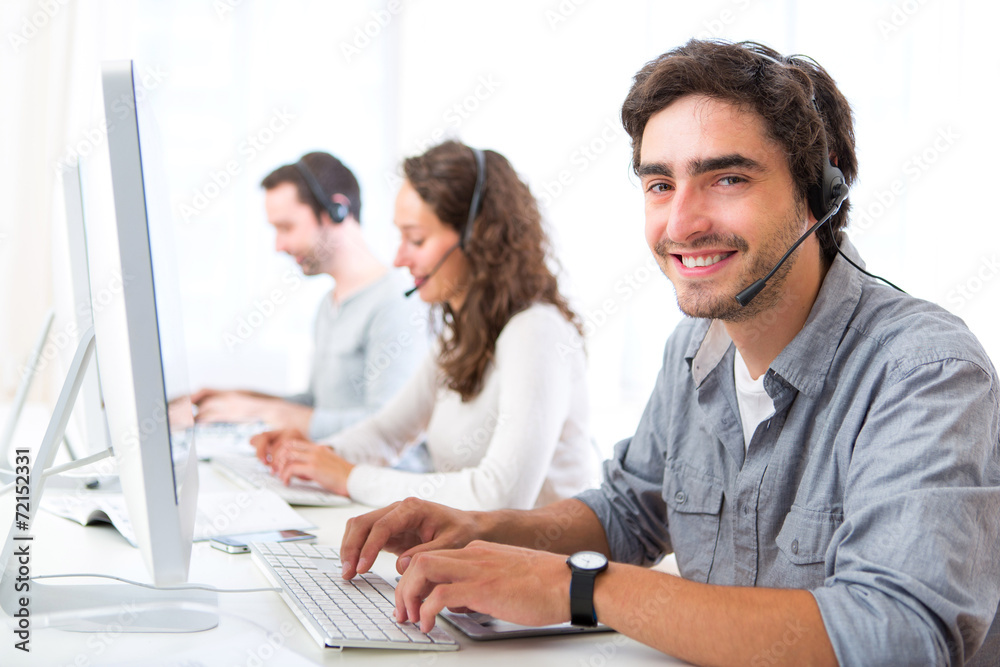 Young attractive man working in a call center