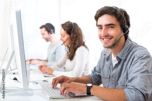 Young attractive man working in a call center © Production Perig