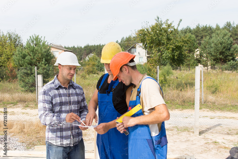 Engineer discussing specifications with workmen Engineer discussing specifications with workmen