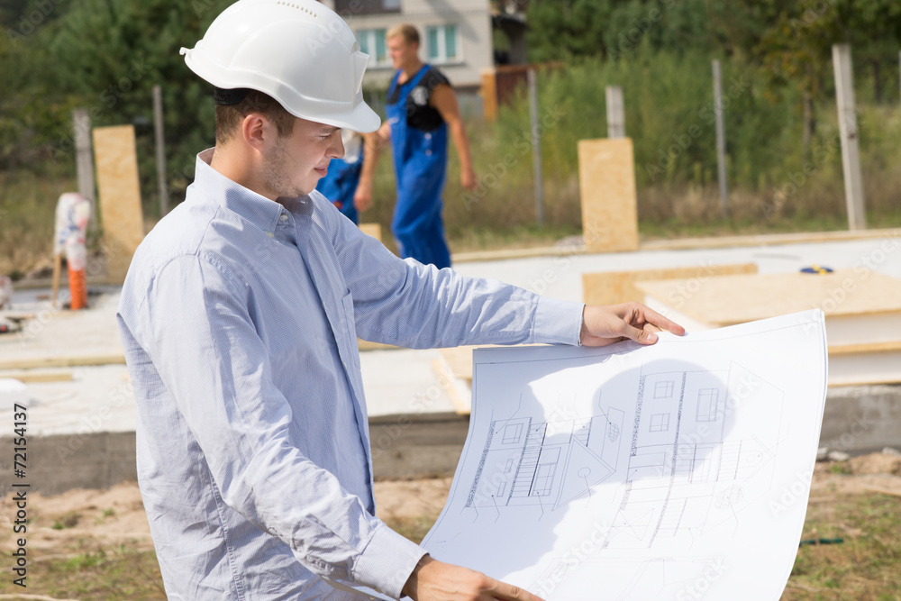 Young architect checking a structural drawing Young architect checking a structural drawing