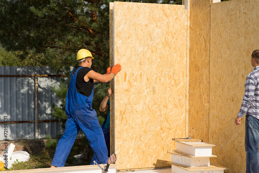 Construction workers installing prefab walls