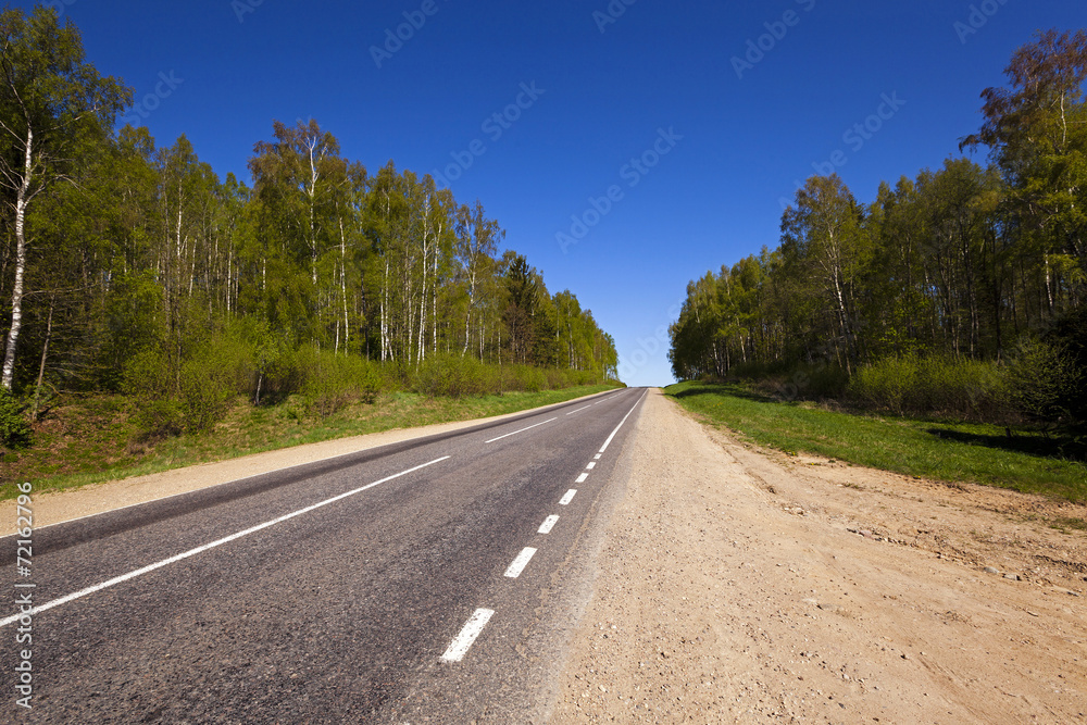 Fototapeta premium the asphalted road - the small rural asphalted road photographed in summertime of year. Belarus