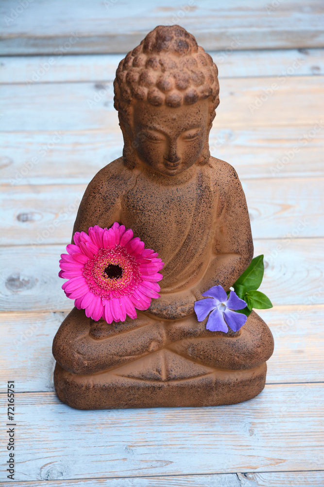 Boeddha beeld op oud met bloemen en zen stenen Stock-Foto | Adobe Stock
