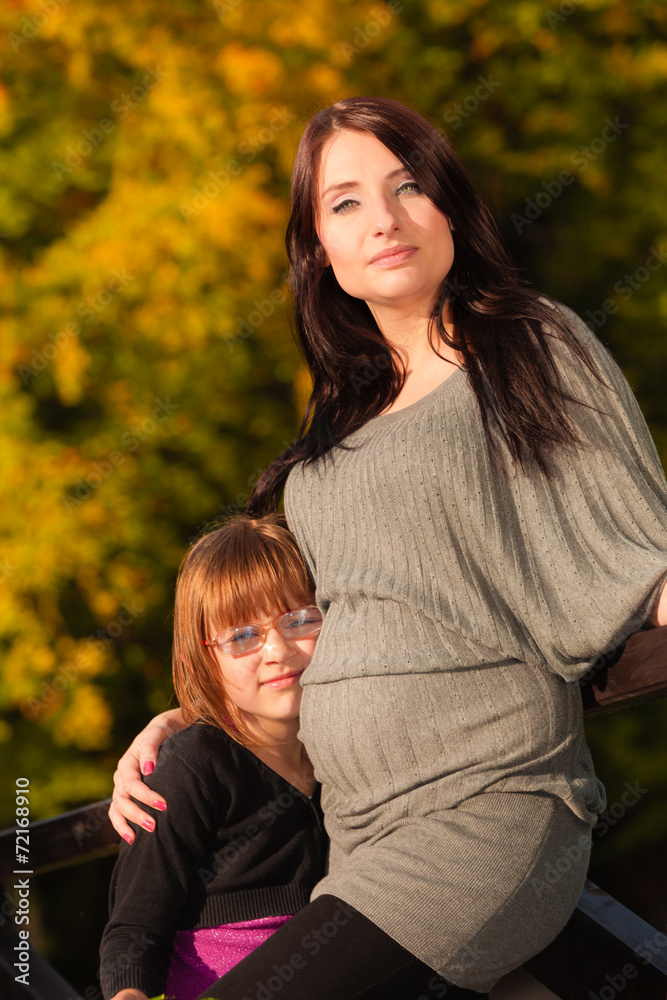 pregnant woman with her daughter in park outdoor pregnant woman with her daughter in park outdoor