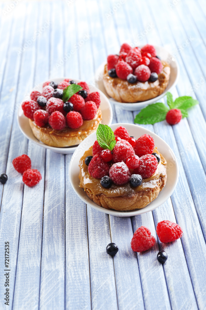 Sweet cakes with berries on table close-up Sweet cakes with berries on table close-up