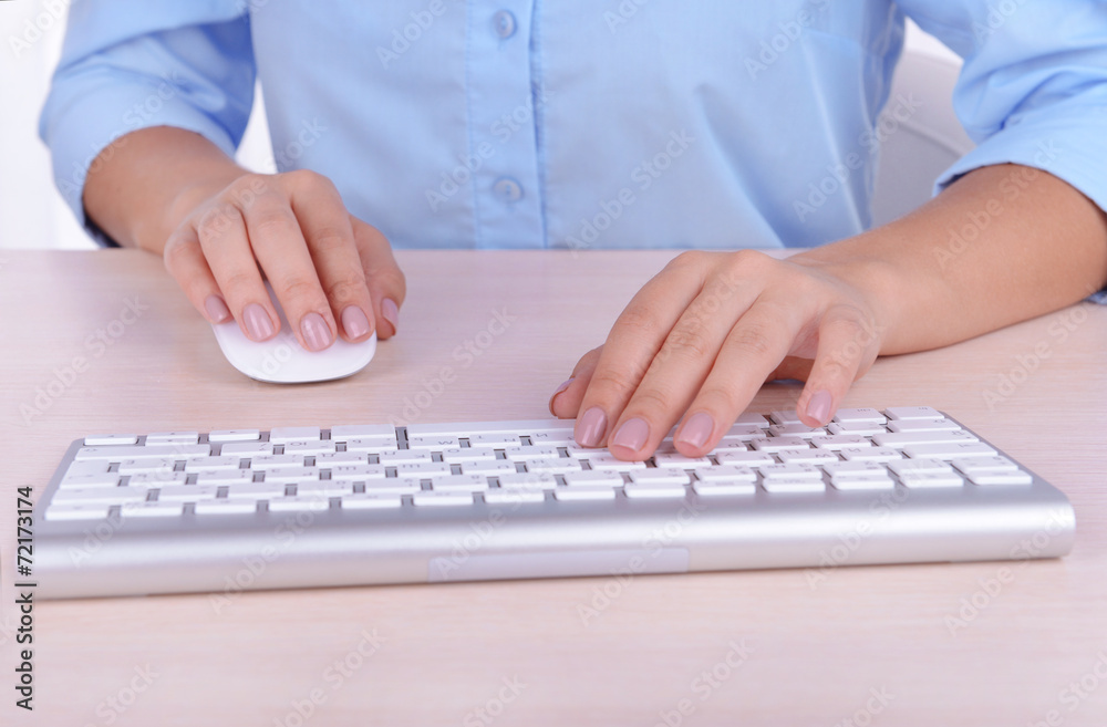 Female hands typing on keyboard on light background Female hands typing on keyboard on light background