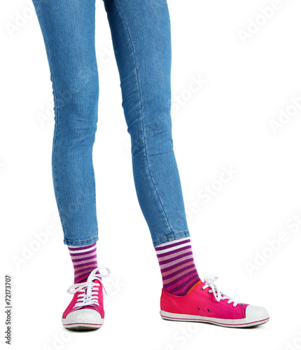 Female legs in colorful socks and sneakers isolated on white © Africa Studio