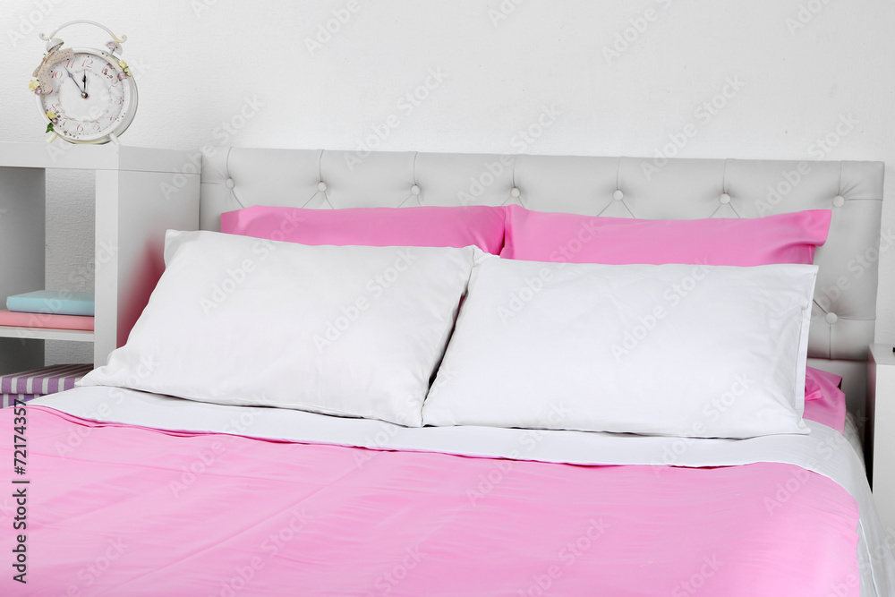 Bed in pink bed linen in room