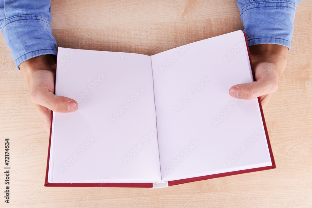 Men reading empty open book on wooden table background