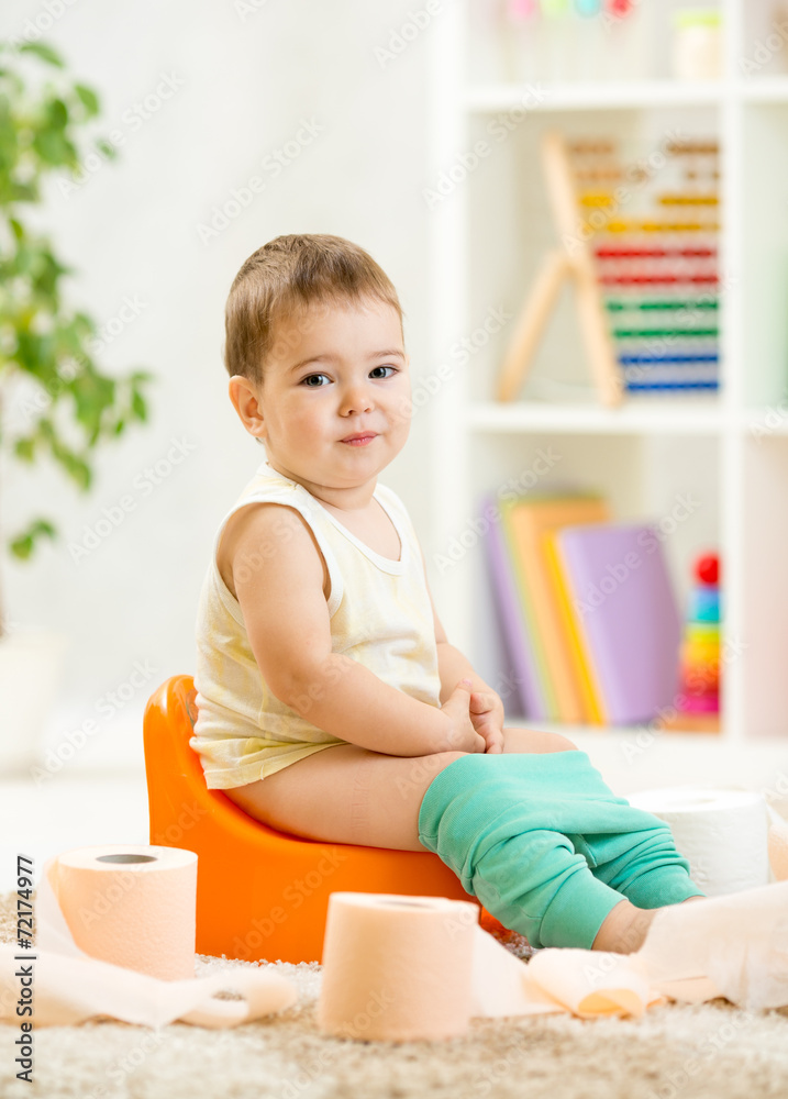 smiling child sitting on chamber pot with toilet paper smiling child sitting on chamber pot with toilet paper