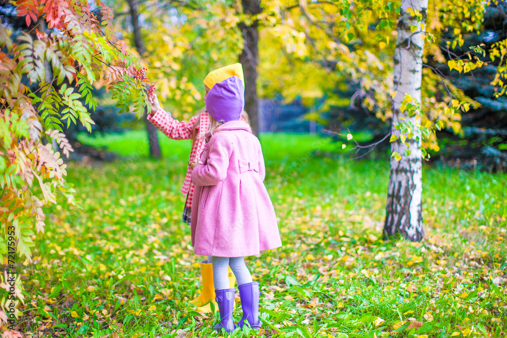 Two adorable girls in forest at warm sunny autumn day Two adorable girls in forest at warm sunny autumn day