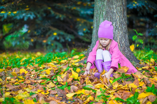 Little adorable girl in autumn park on sunny fall day