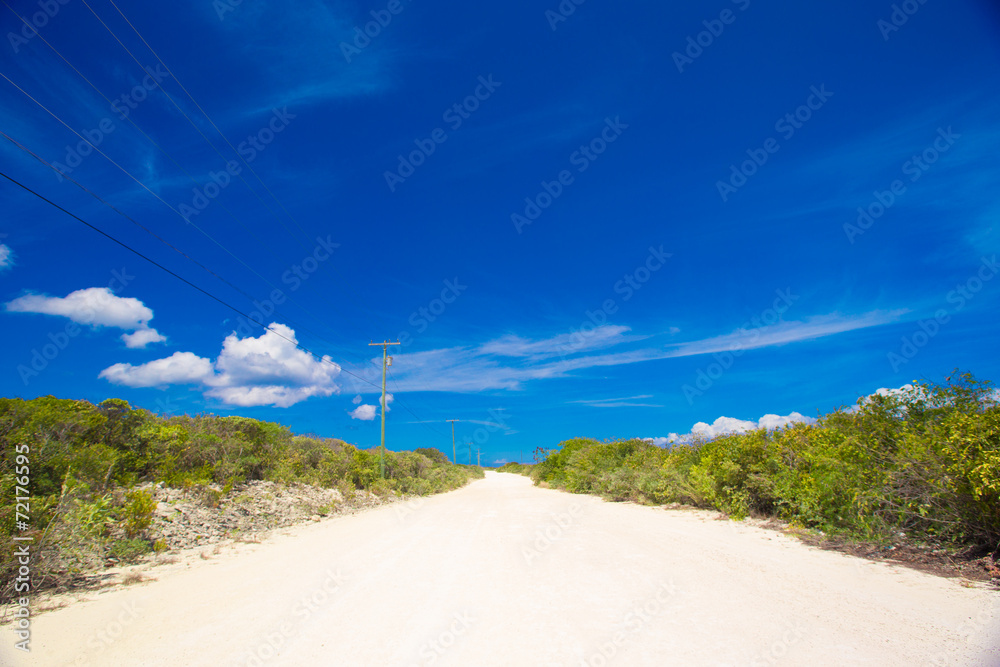 Deserted tropical road with white sand on Caribbean island