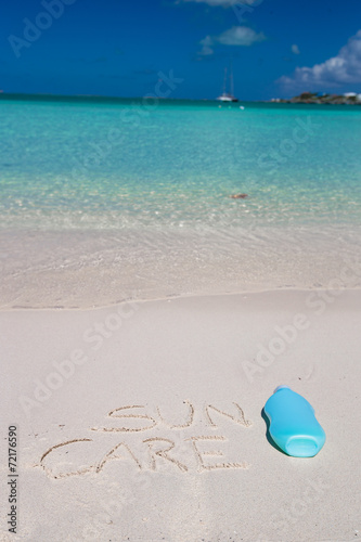 Suncare written on tropical white sand and suncream