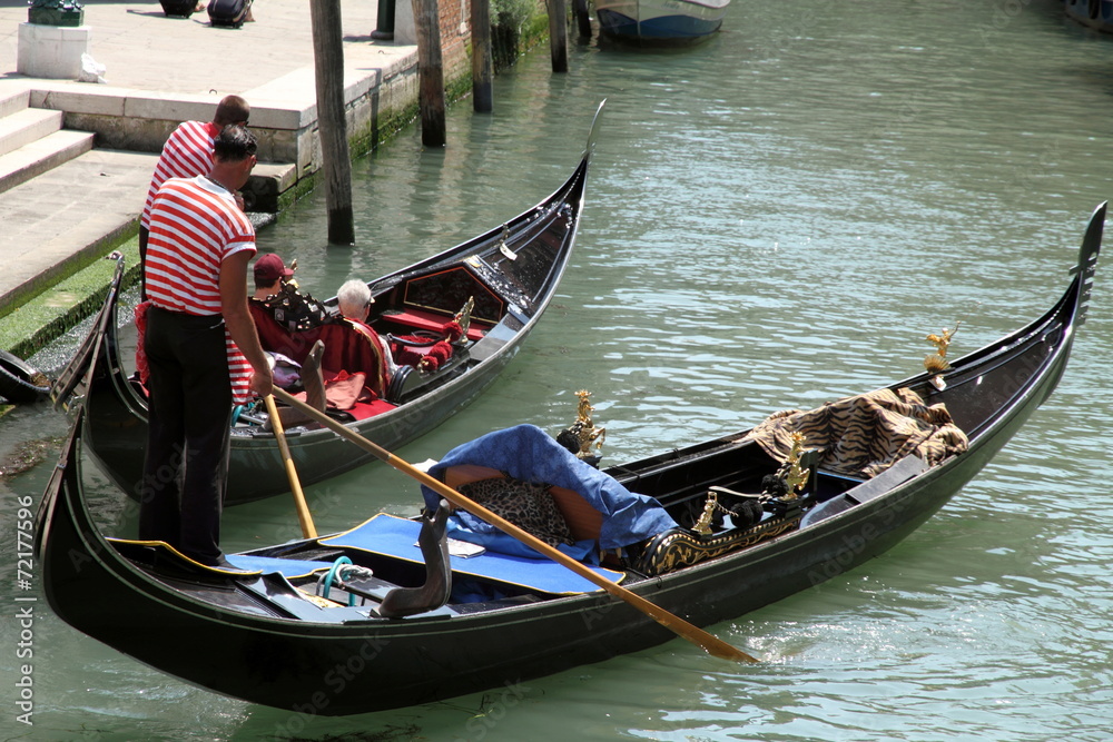 Gondoliers with tourists on canal, Venice, Italy