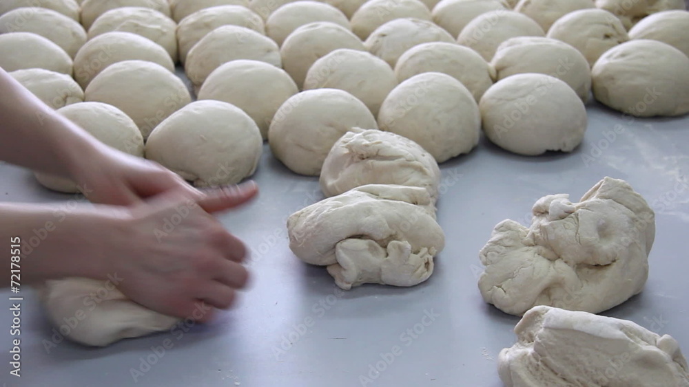 Baker kneading dough in a bakery Baker kneading dough in a bakery