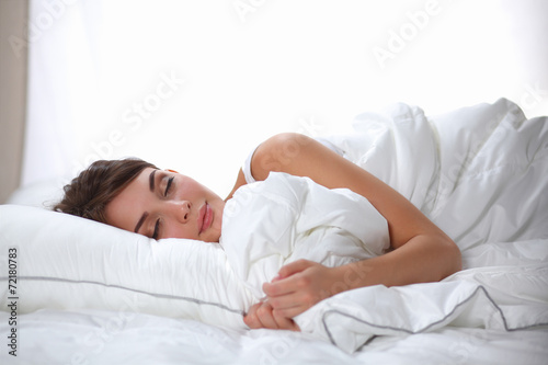 Beautiful girl sleeps in the bedroom, lying on bed © lenets_tan