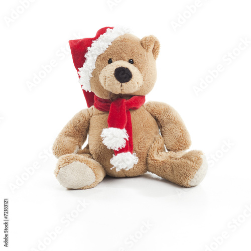 Teddy bear with christmas hat and scarf over white background