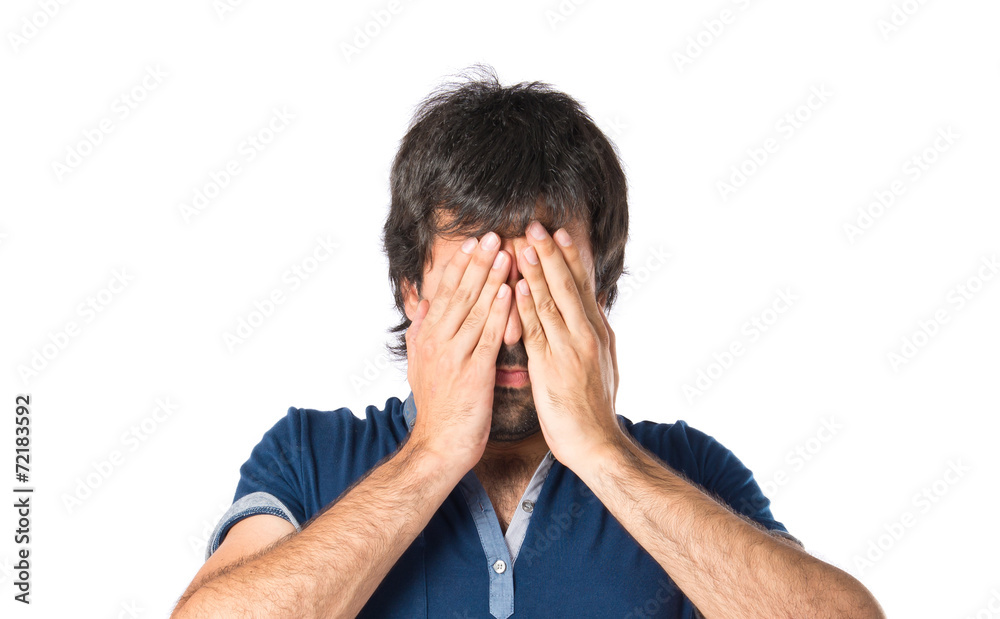 Man covering his eyes over isolated white background Man covering his eyes over isolated white background