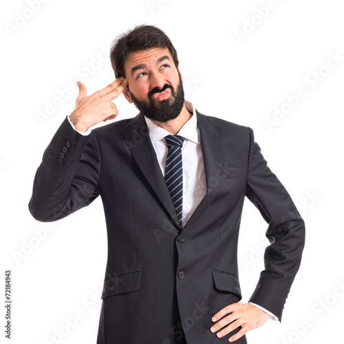 Businessman making gun gesture over white background