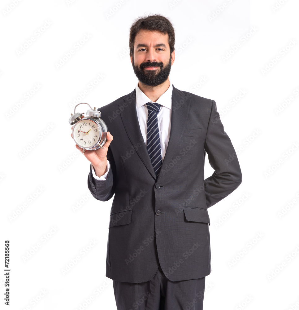 Businessman holding a clock over white background Businessman holding a clock over white background