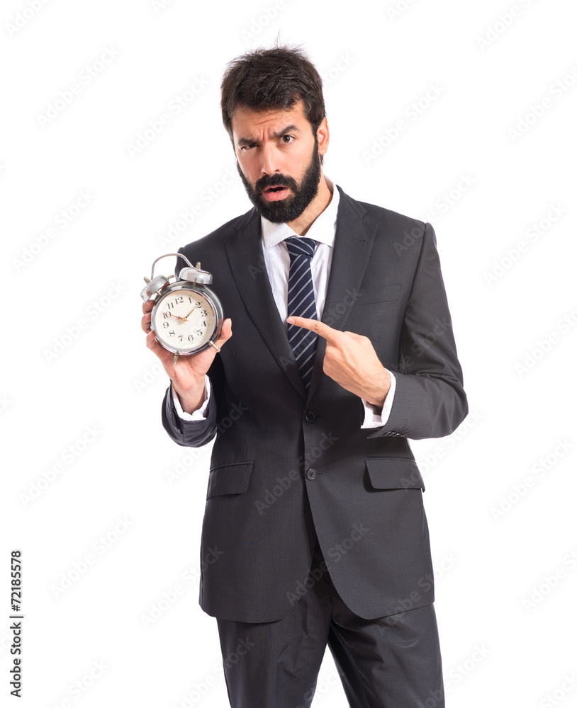 Businessman holding a clock over white background Businessman holding a clock over white background