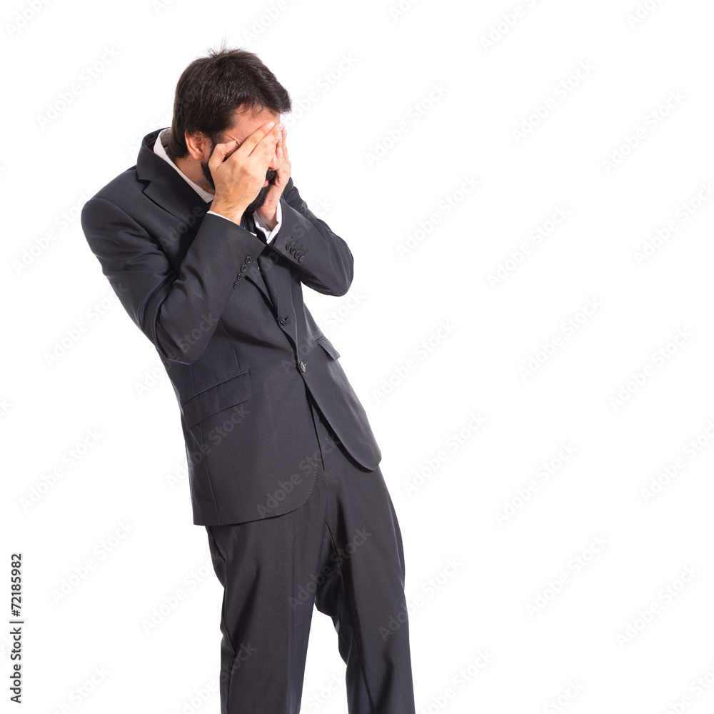 Businessman covering his eyes over isolated white background Businessman covering his eyes over isolated white background