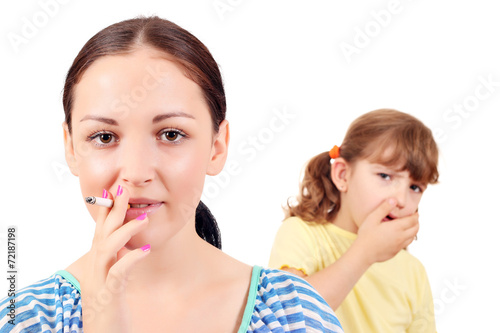 girl smoking cigarette and little girl coughs
