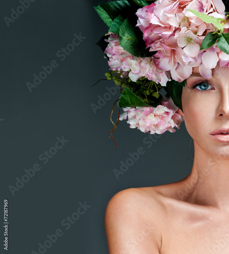 fashion model with large hairstyle and flowers in her hair. © Svetlana Fedoseeva