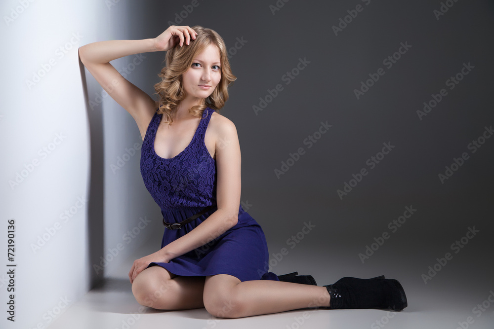 Beautiful woman in violet dress on grey