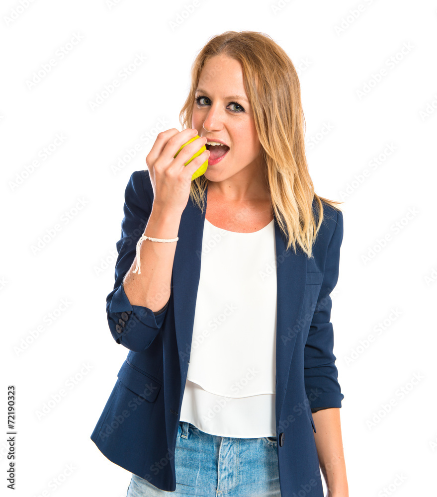 Blonde girl eating an apple over white background Blonde girl eating an apple over white background