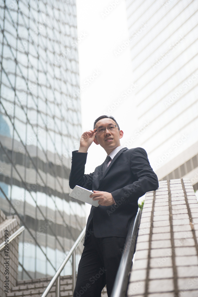 asian businessman with tablet computer on busy hong kong centra asian businessman with tablet computer on busy hong kong centra