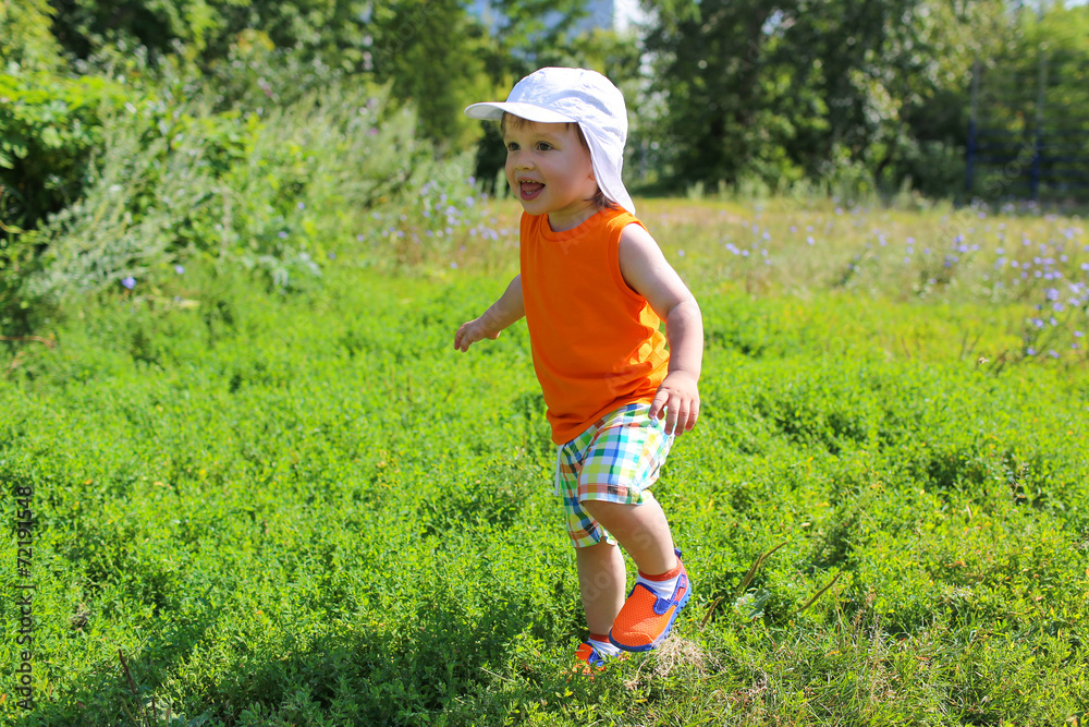 happy baby boy running outdoors in summertime