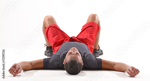 Atleta deportista agotado recostado en el piso.
