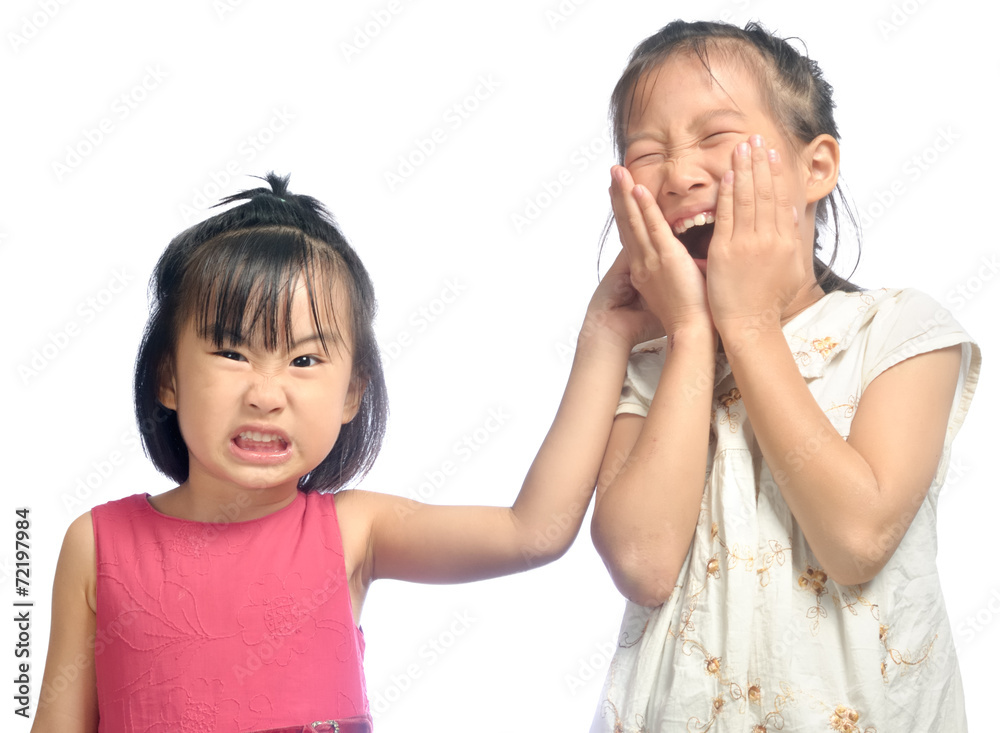 Siblings teasing, asian little girl pulling her sister's ear Siblings teasing, asian little girl pulling her sister's ear