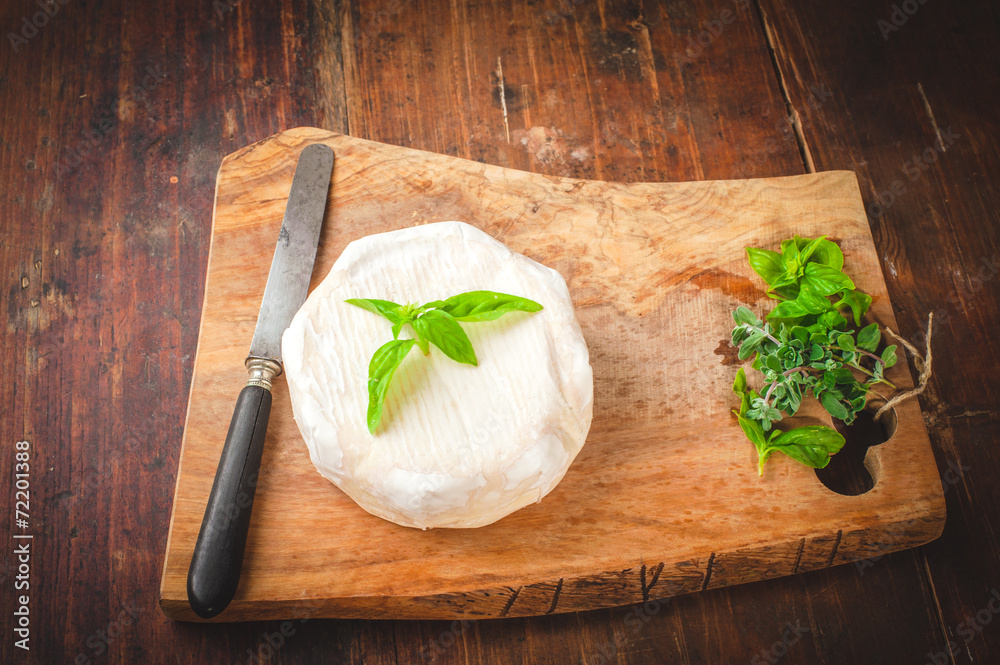 Smelly blue cheese on a wooden rustic table with knife and basil Smelly blue cheese on a wooden rustic table with knife and basil