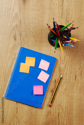 Cuaderno y lápices de colores en un bote photo