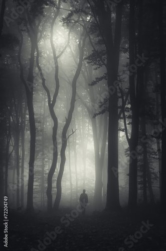 man walking in mysterious dark forest