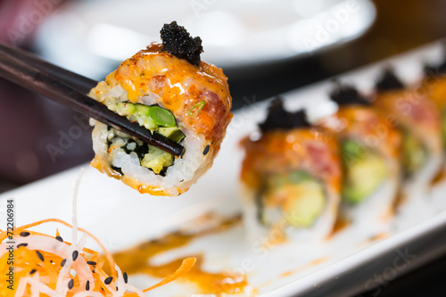 Sushi roll with black chopsticks