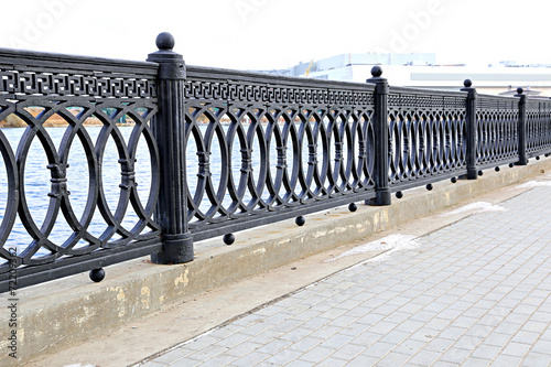 Cast iron grate fence on the embankment