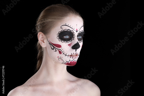 Woman with dia de los muertos makeup, black empty space.