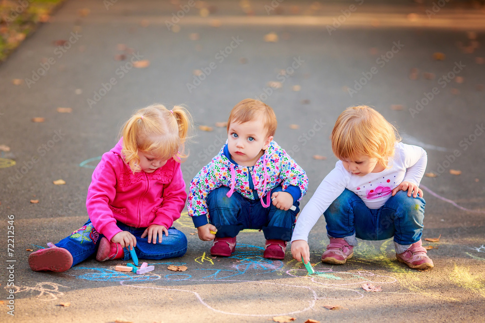 Obraz premium happy children draw with crayons on the pavement in the park