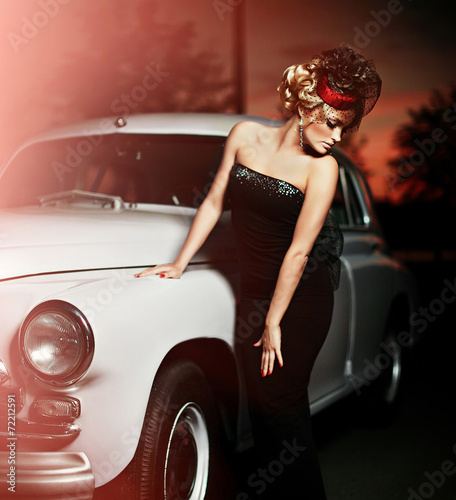 sexy stylish blond model in retro style near old car