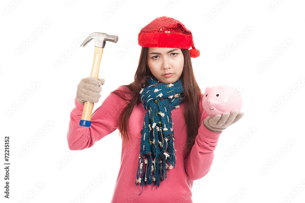 Asian girl with red christmas hat ,hammer and piggy bank Asian girl with red christmas hat ,hammer and piggy bank