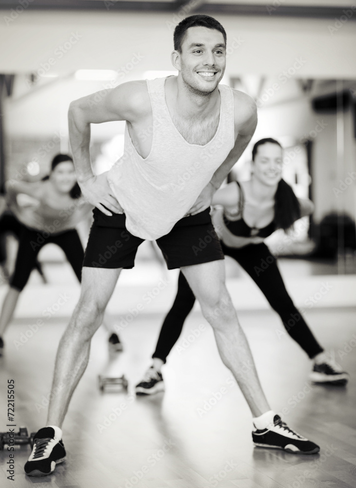 smiling male trainer working out in the gym