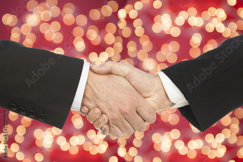 business handshake on multicolor bokeh light background.