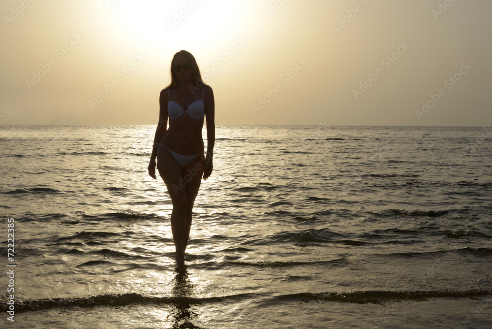Beautiful woman in bikini on sunset background