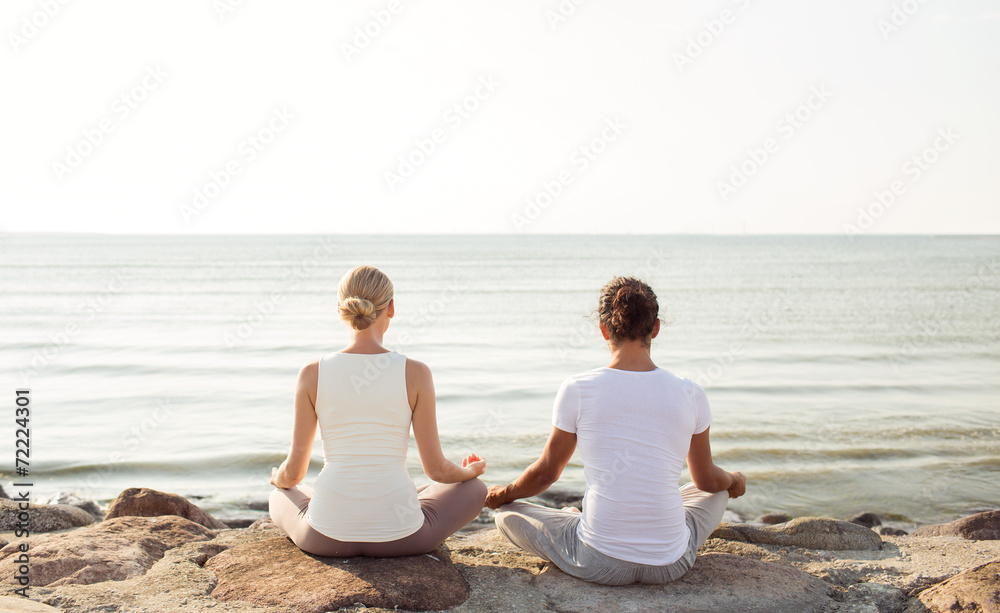 Fototapeta premium couple making yoga exercises outdoors